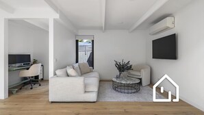 Ein modernes Wohnzimmer mit Sofa, Couchtisch und Fernseher.