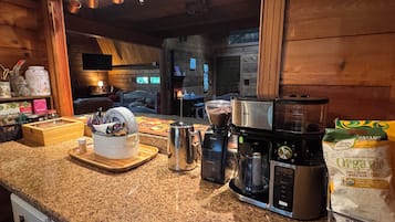 Eine Küche mit Granit-Arbeitsplatten, einer Kaffeemaschine, einem Mixer und einer Packung Bio-Kaffeebohnen.