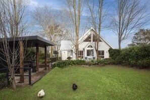 Une maison dotée d’un espace extérieur aménagé, abrité, et d’une pelouse bien entretenue.