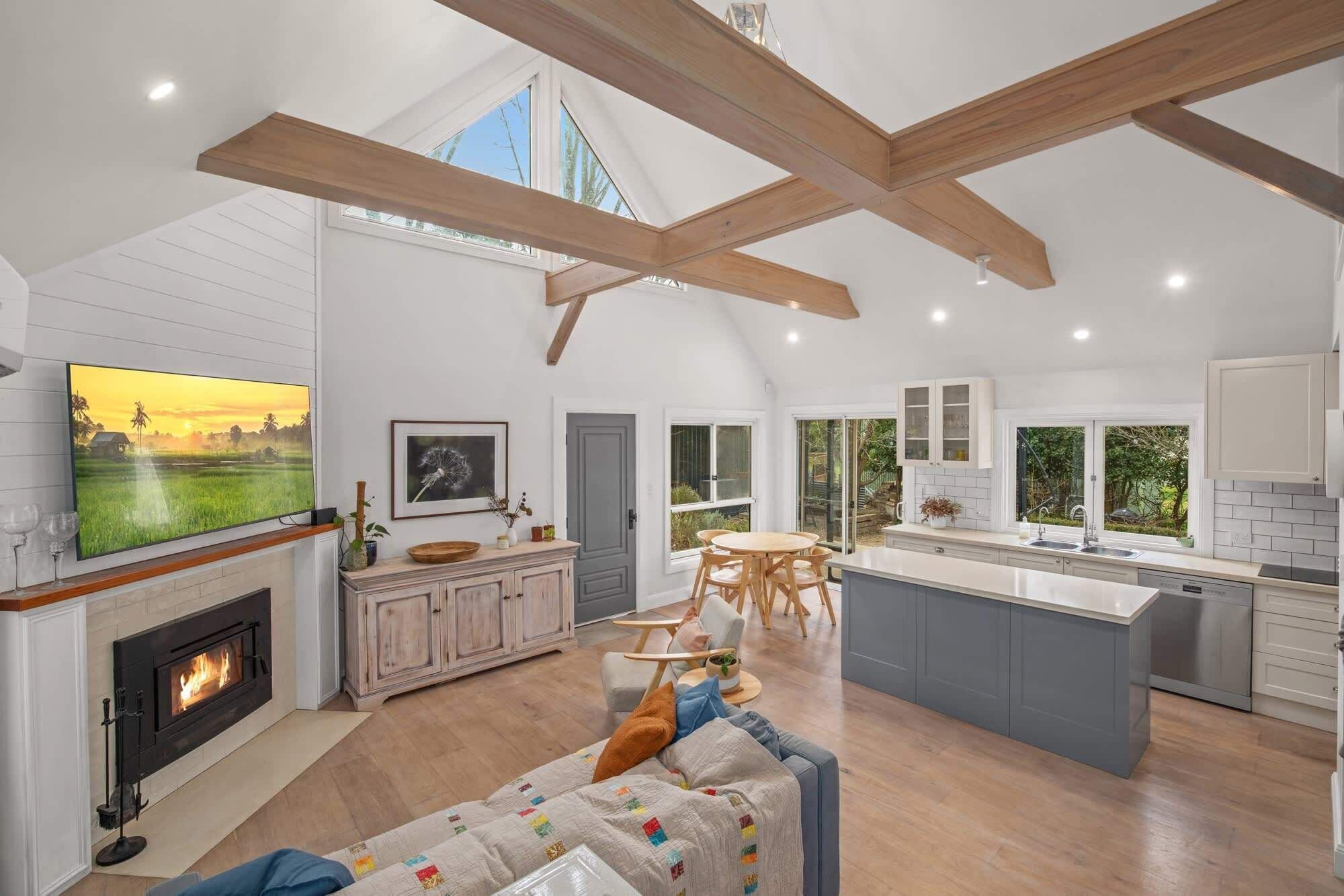 A spacious living room with a fireplace, a large TV, and a cozy seating area.