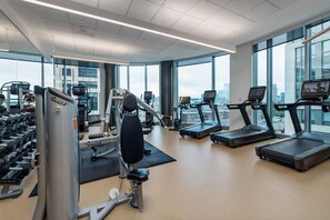 Ein modernes Fitnessstudio mit Laufbändern, Kraftgeräten und Kurzhanteln.