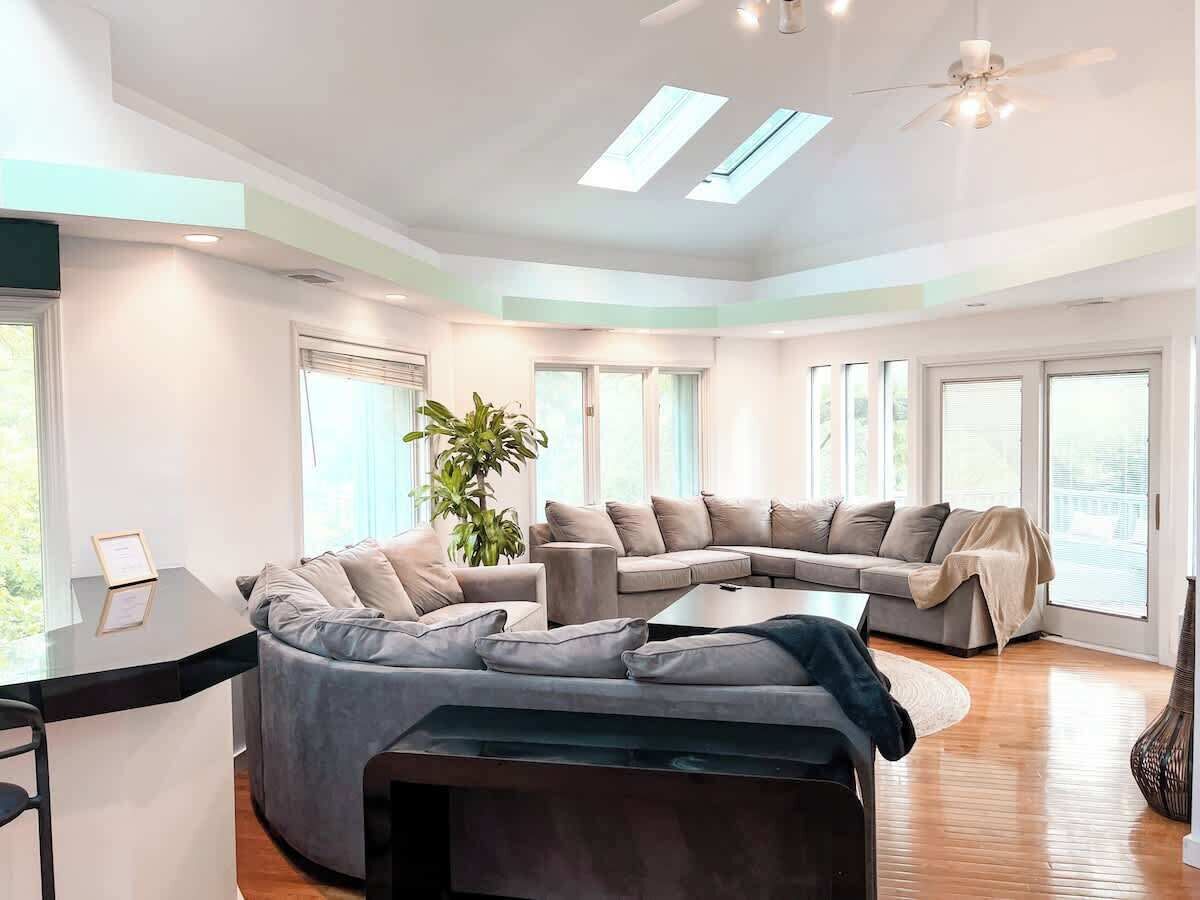 A modern living room with a sectional sofa, a coffee table, and a desk with a computer.
