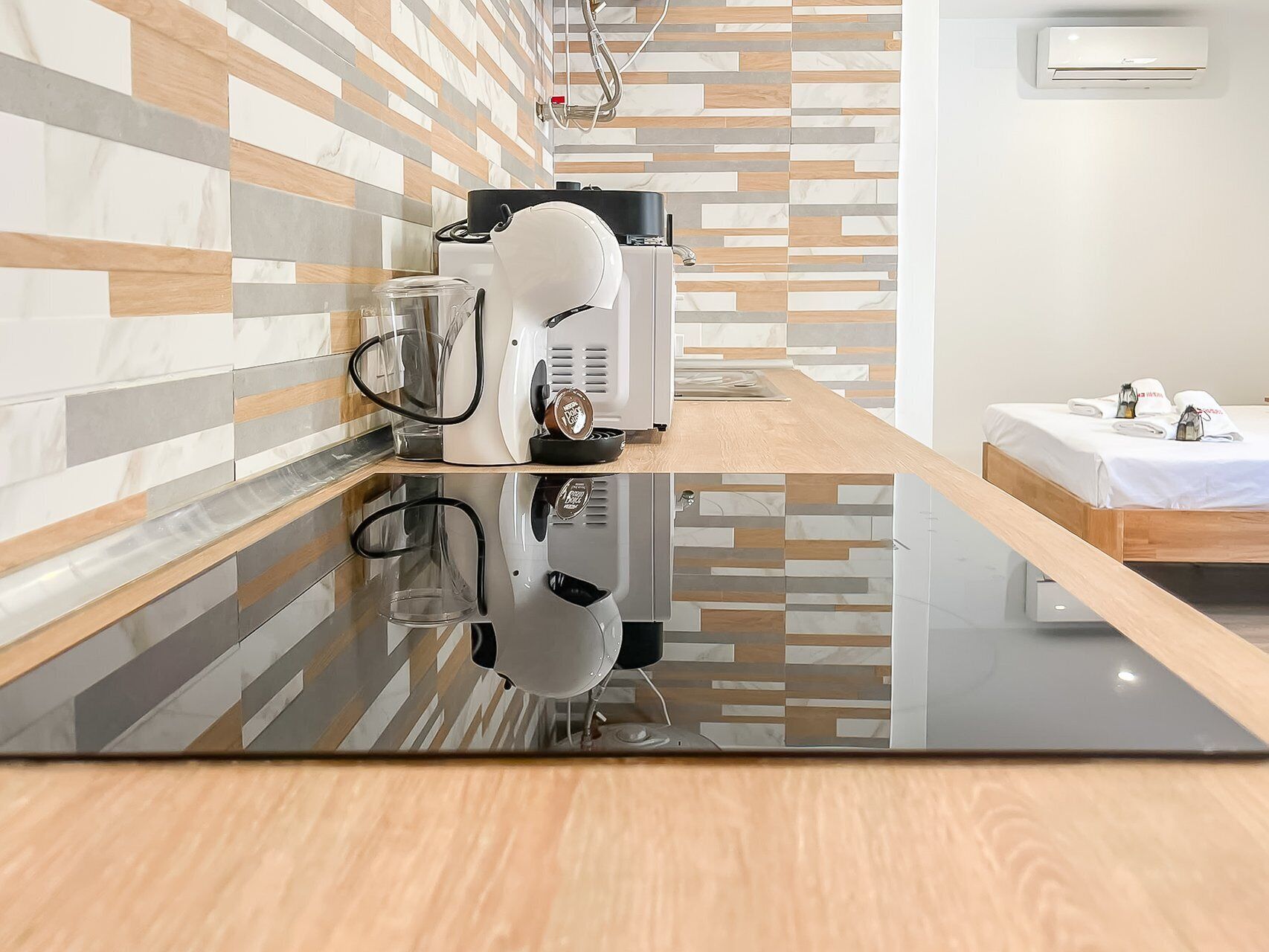 A modern kitchen with a sleek black countertop, a coffee machine, and a kettle.