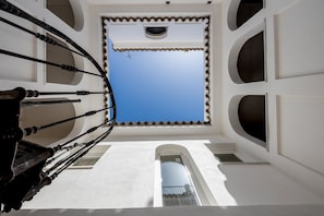 A spiral staircase leading to a balcony with a clear blue sky view. - GuestReady - Casa Espelete 1B (El Puerto de Santa María)