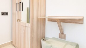 Una camera moderna con un'armadiatura in legno, una panca, uno specchio e uno scaffale a parete.