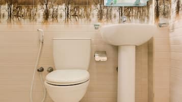 A bathroom with a toilet, sink, and a mirror above the sink.