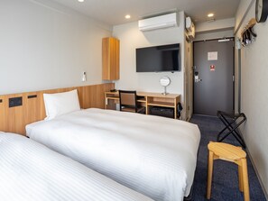 A hotel room with two beds, a desk, a chair, a TV, and an air conditioning unit. - Toyoko Inn Toyohashi Ekimae Odori (Toyohashi)