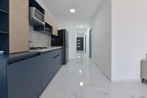 A modern kitchen with a built-in microwave, a refrigerator, and a coffee machine. - Sleek 2BR Retreat, Tanki Leendert (Tanki Leendert)