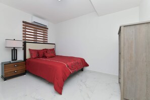 A bedroom with a bed, nightstand, lamp, and a wardrobe. - Sleek 2BR Retreat, Tanki Leendert (Tanki Leendert)