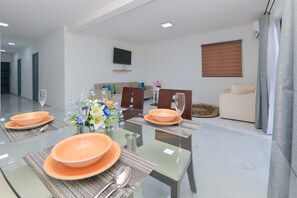 A modern living room with a dining area set for four. - Sleek 2BR Retreat, Tanki Leendert (Tanki Leendert)