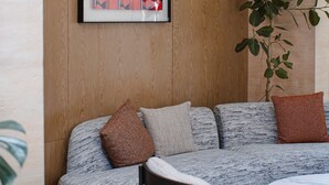 Ett modernt vardagsrum med en soffa, ett soffbord och ett inramat konstverk på väggen.