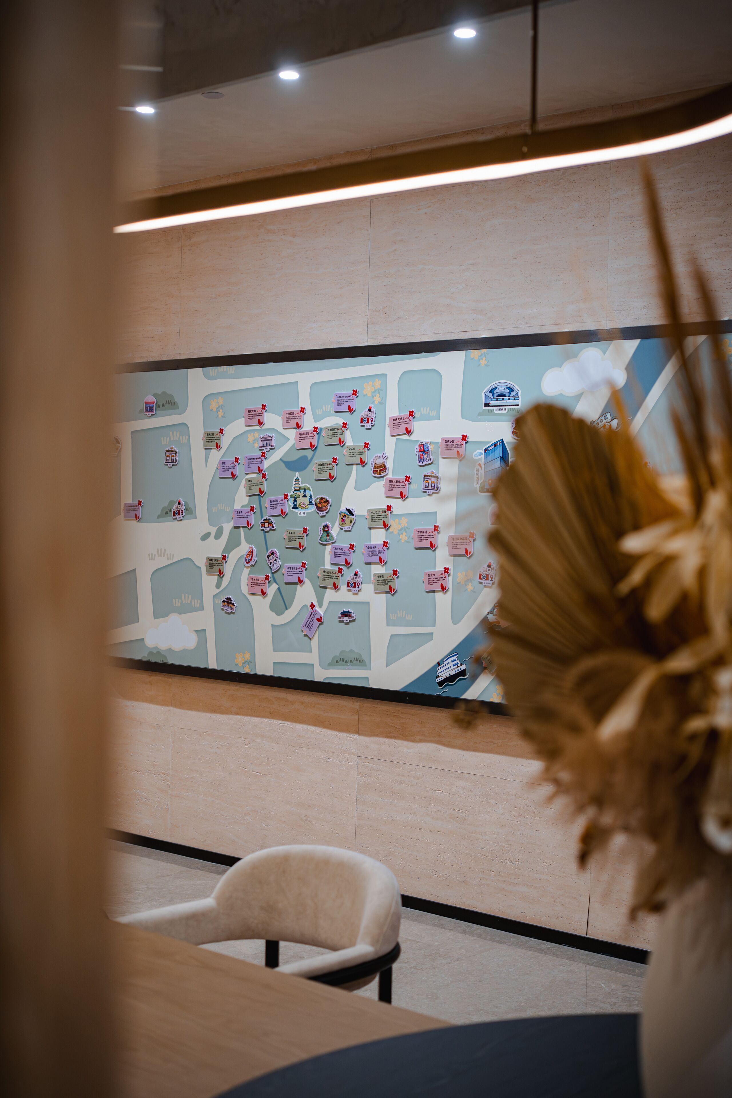 Un mapa con varios iconos y etiquetas, una silla blanca, y una mesa en una habitación con suelo de madera y una lámpara en el techo.
