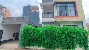 Un edificio residencial moderno de dos pisos con un balcón y un ventanal grande.