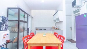 Una cocina compacta con una mesa, sillas y un refrigerador.