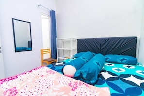 A bedroom with a bed, a chair, a shelf, and a mirror. - Cozzy Villa Tera (batu)