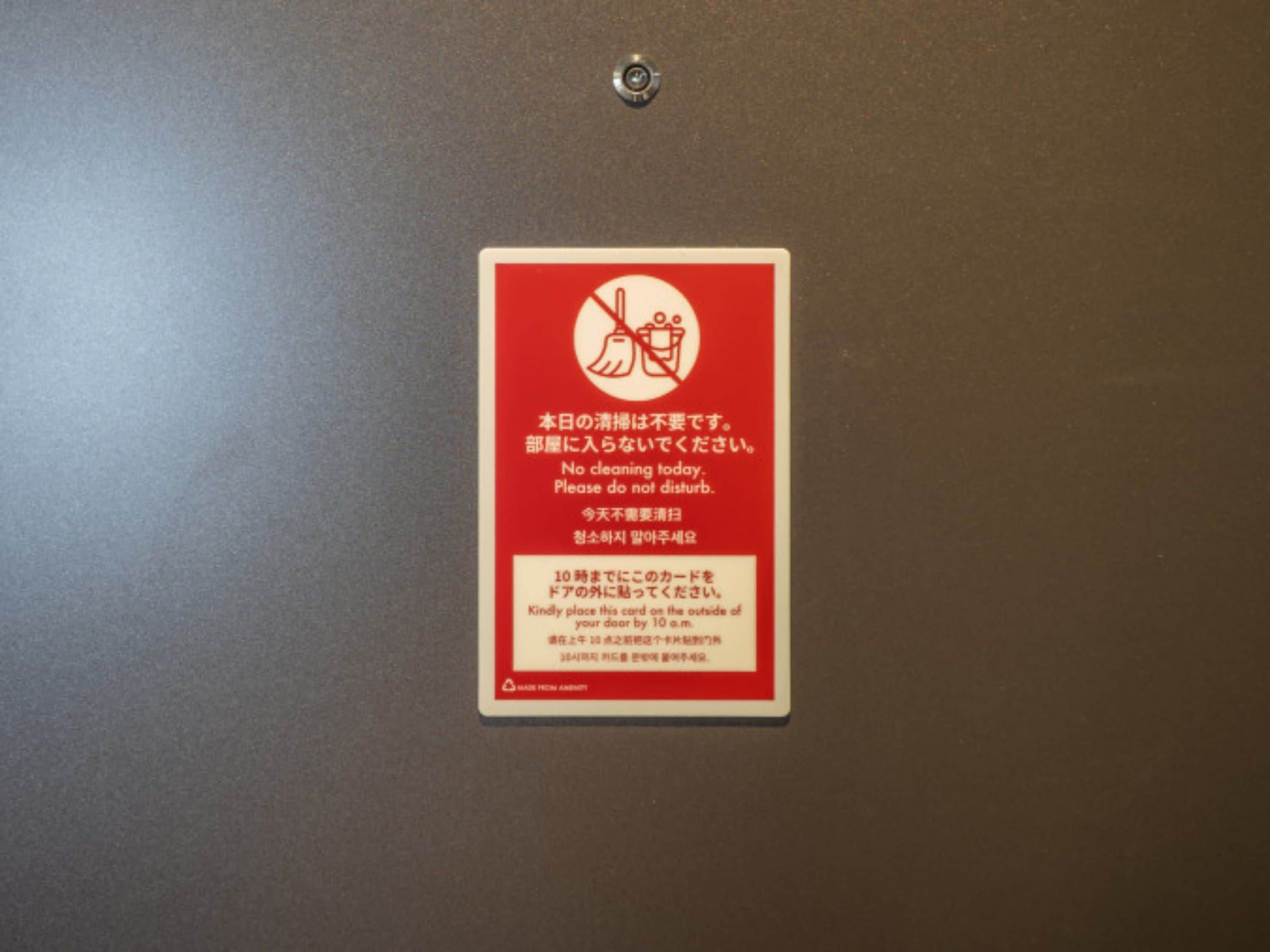 A red sign with white text and symbols indicating no cleaning today and a request not to disturb.