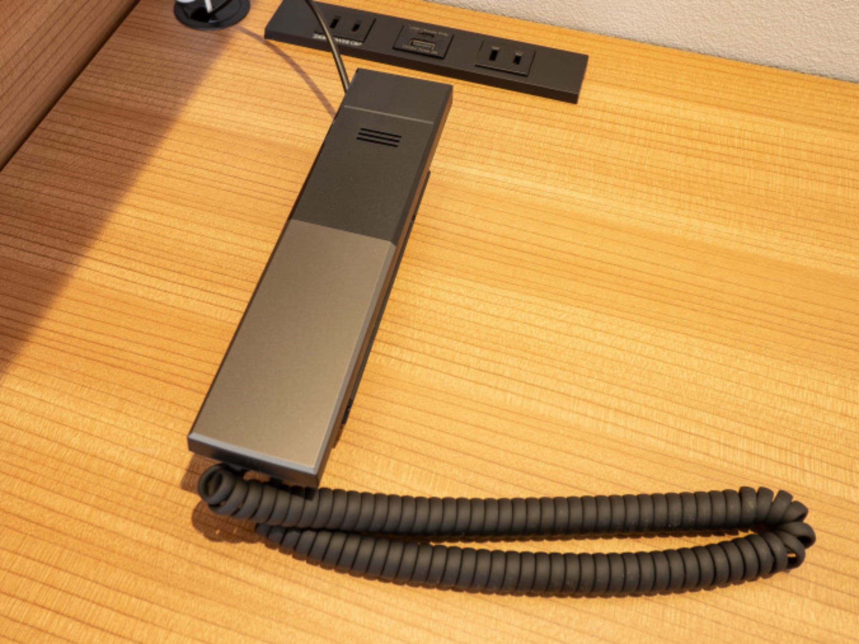 Een stekkerdoos met meerdere stopcontacten en een opgerolde kabel op een houten oppervlak.