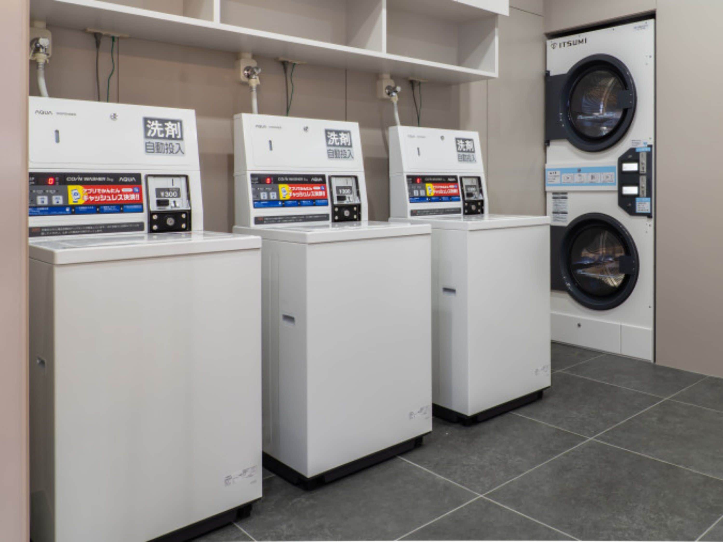 A laundry facility with three washing machines and a large front-loading washer.
