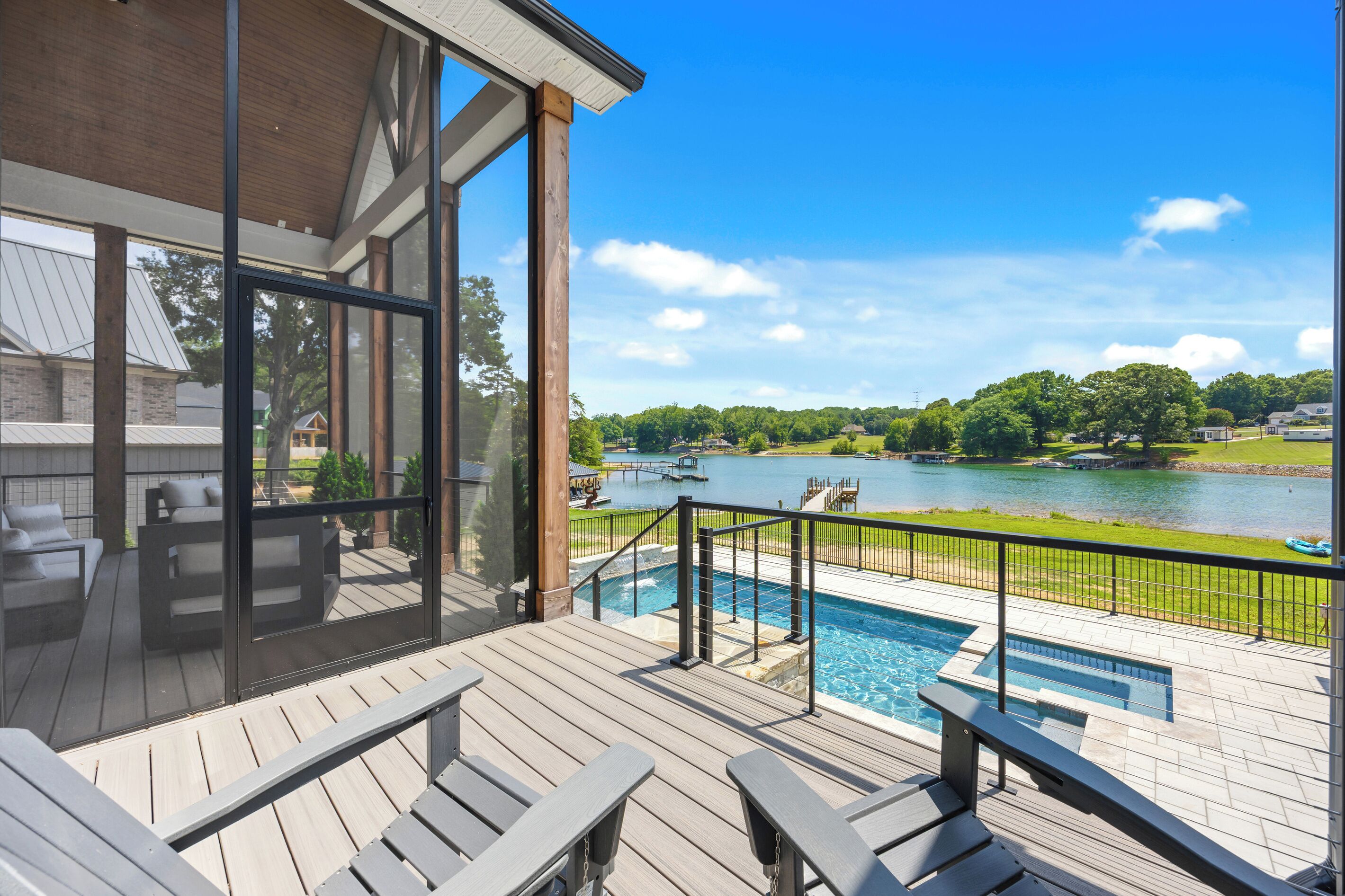 A pool area with a view of a lake and surrounding landscape.