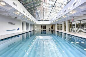 Ein moderner, überdachter Innenpool mit klarem Wasser und einer Rettungswache.