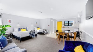 Ett modernt hotellrum med två sängar, en matplats och utsikt över omgivningarna.