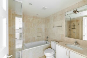 A bathroom with a bathtub, toilet, and sink. - Blueground | Penn Quarter, pool, nr National Gallery (Washington, D.C.)