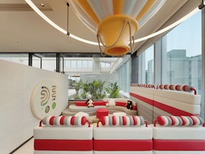 Un interior moderno con una zona de estar, un ventanal grande y un diseño de techo único.