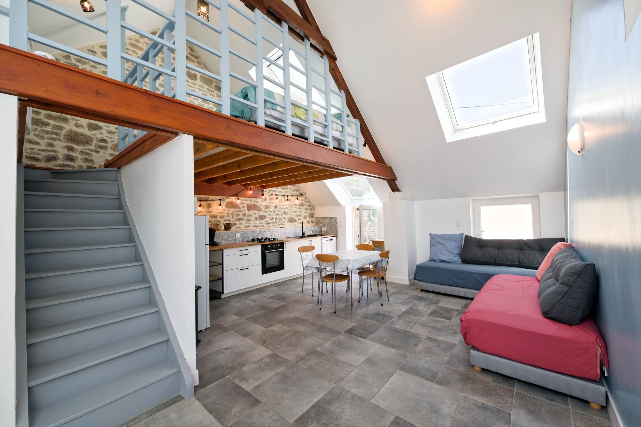 A spacious loft with a kitchen, dining area, and seating space.