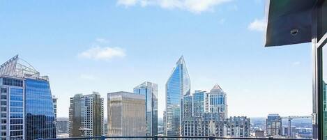 A city skyline with modern high-rise buildings, including a distinctive pointed skyscraper.