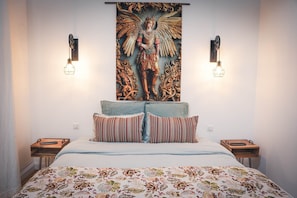 Un dormitorio con una cama grande, dos mesitas de noche, una obra de arte en la pared y dos lámparas de pared.