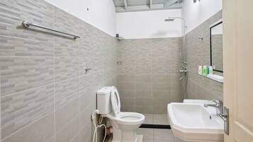 Un baño moderno con inodoro, ducha y lavamanos.