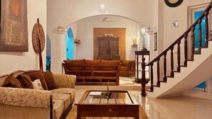 A spacious living room with a wooden staircase, a sofa set, and a coffee table. - Skyport Villa Negombo (Negombo)