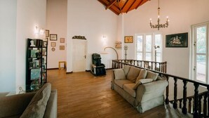 A spacious living area with a wooden floor, a staircase, and a chandelier. - Skyport Villa Negombo (Negombo)