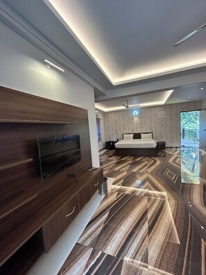 A modern bedroom with a flat-screen TV, a bed, and a patterned floor. - Marshmallow By MA Homes (Morjim)
