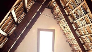 A room with a sloped ceiling, two beds, a window, and a wooden floor. - "El Nirvana" Oceanfront Cabin: Surf & Desert (Punta Abreojos)