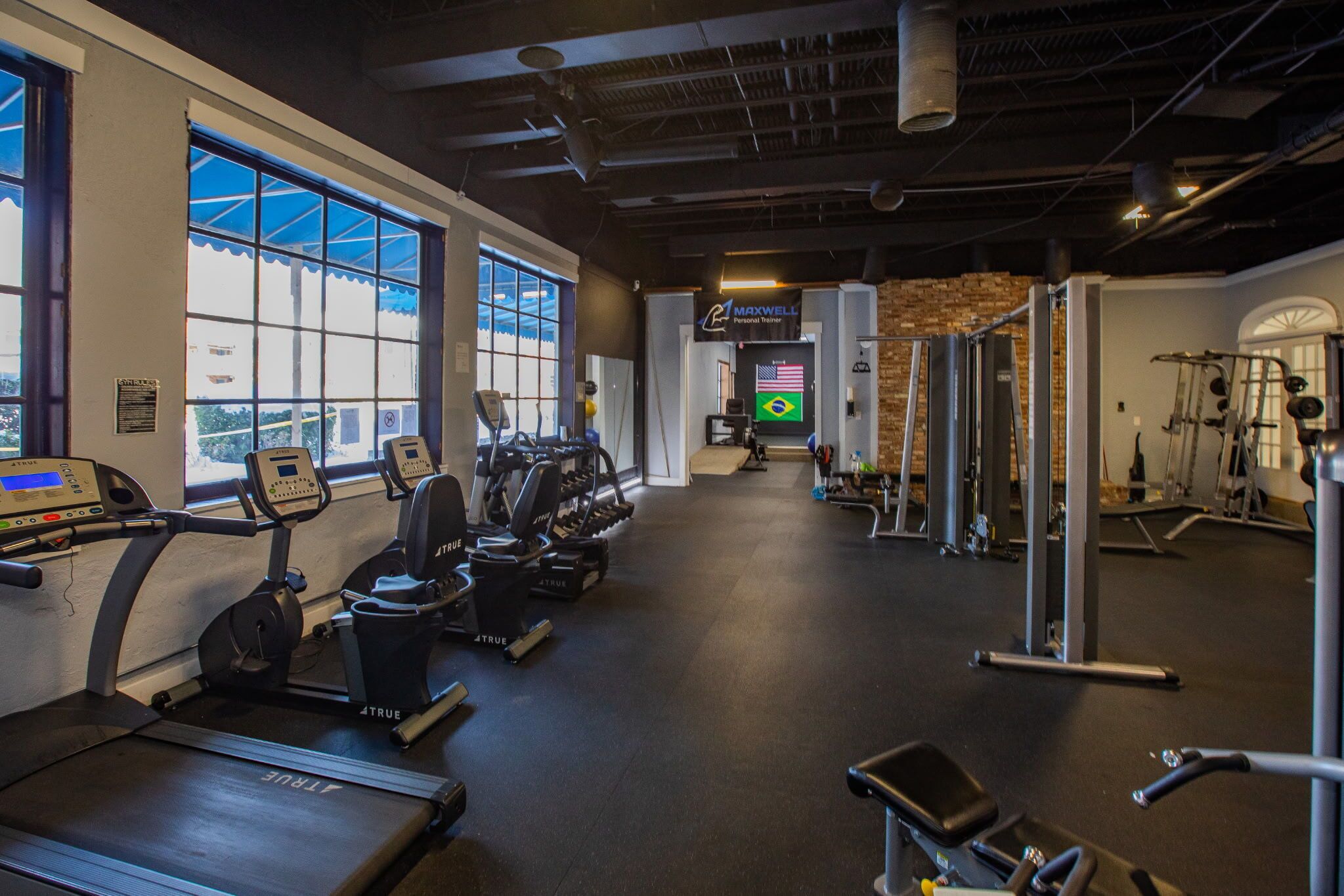 A gym with treadmills, elliptical machines, and weightlifting equipment.