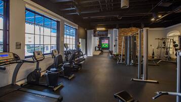A gym with treadmills, elliptical machines, and weightlifting equipment.