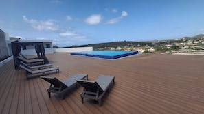 A rooftop deck with a pool and lounge chairs. - Nice View Apt 5 - 2-BR apartment with AC on spectacular Mahuma hill (Mahuma (Curacao-Middle))
