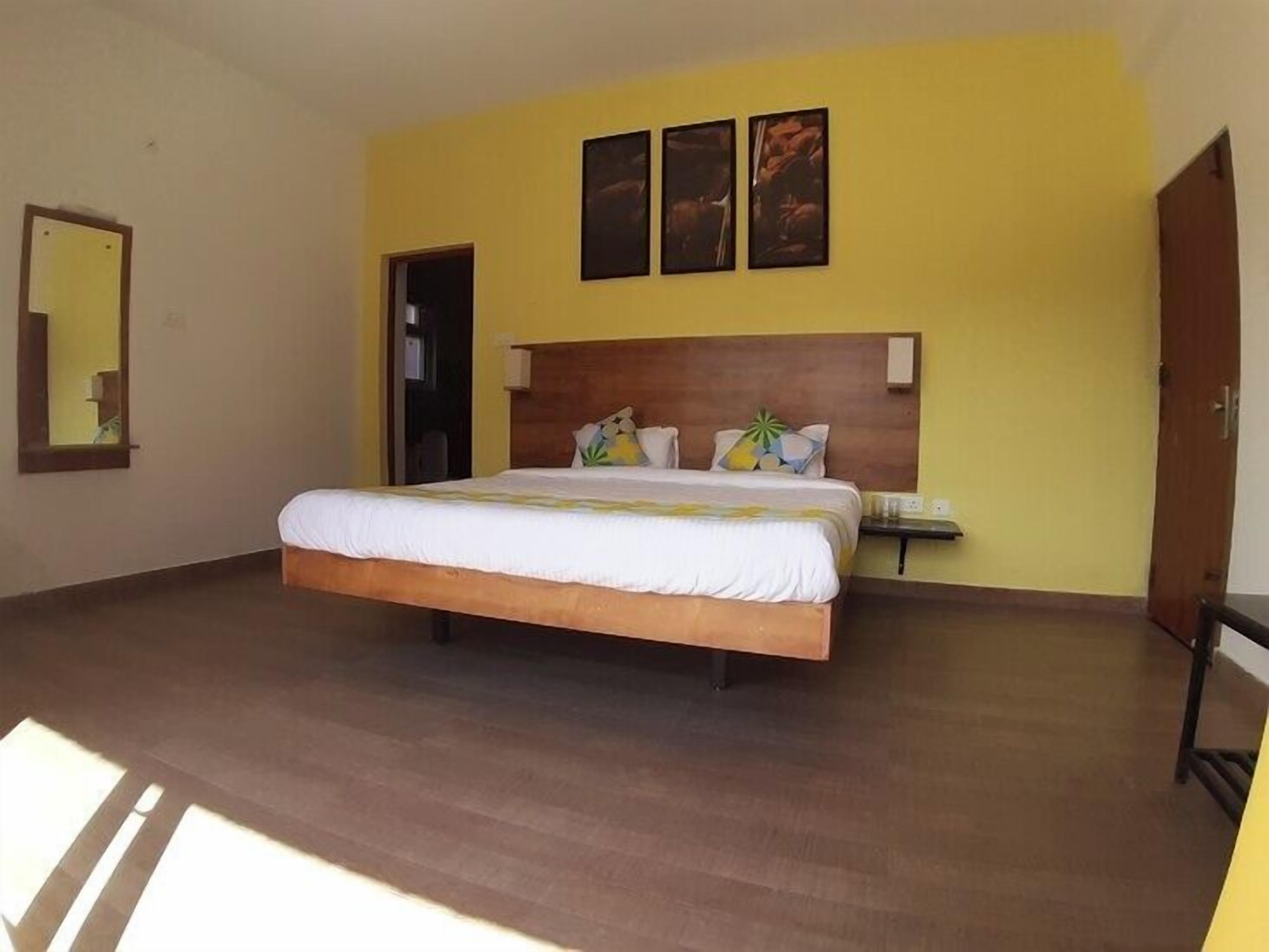 Un dormitorio con una cama grande, un cabecero de madera, una mesita de noche y una puerta.