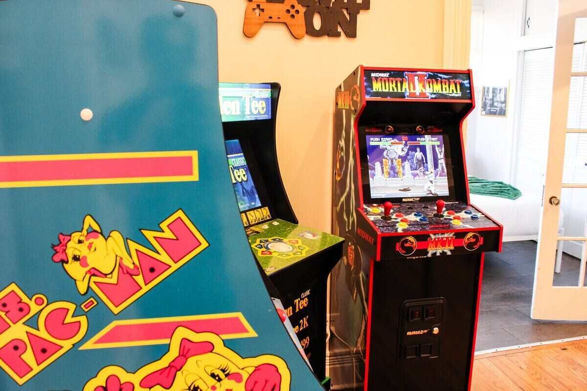 Una stanza con apparecchiature arcade, tra cui una macchina di Pac-Man e un'arcade di Mortal Kombat.