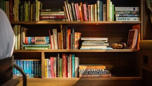 A bookshelf with a variety of books, including travel guides and gardening books.
