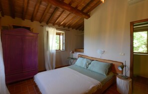 A bedroom with a bed, a wardrobe, a window, and a mirror. - Podere Frassinelli Dependance (Stribugliano)