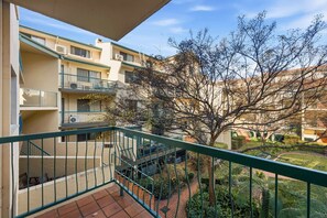 A residential building with multiple balconies, a staircase, and a tree in the courtyard. - Stylish 2-Bed Apartment in Kingston (Kingston)