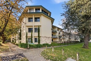 A multi-story residential building with a flat roof, a central entrance, and a pathway leading to the entrance. - Stylish 2-Bed Apartment in Kingston (Kingston)
