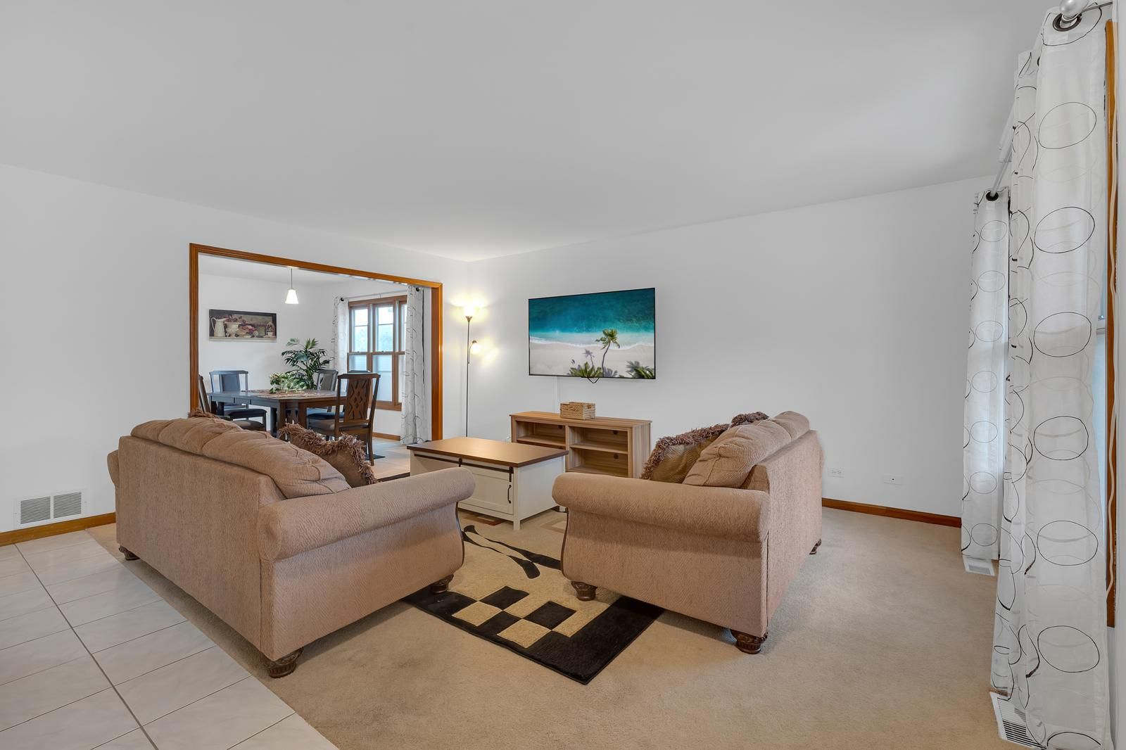 Ein Wohnzimmer mit zwei Sofas, einem Couchtisch und einem Gemälde an der Wand.