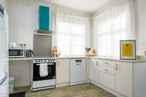 Una cocina compacta con estufa, microondas y lavavajillas.