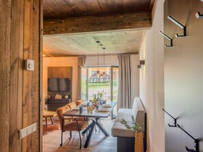 A modern interior with a dining area, a sofa, and a view of the outdoors. - Apartment by lake Afritzer See in the Alps (Afritz am See)