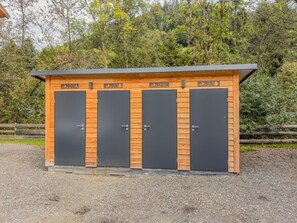 Een houten constructie met vier deuren, elk voorzien van een nummer en een bergpictogram, wat wijst op een gelegenheid met een bergthema.