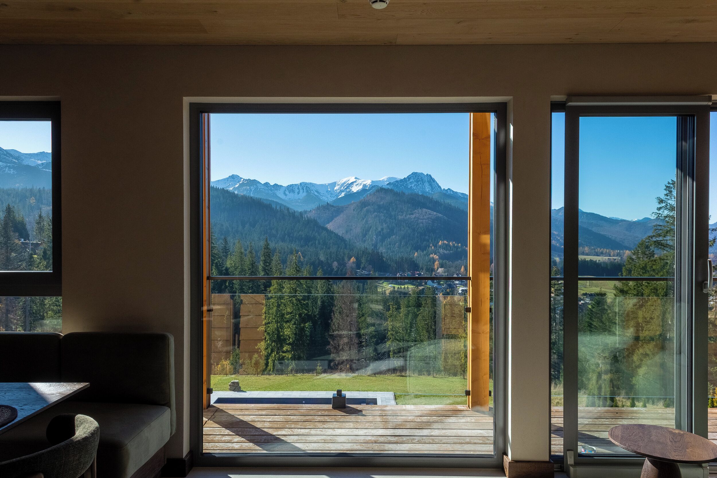 A room with a large sliding glass door leading to a balcony with a mountain view.