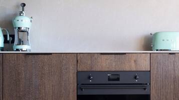A kitchen with wooden cabinets, a built-in oven, and a green wall-mounted light fixture.